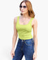 A woman modeling a bright lime green scoop-neck tank top paired with blue jeans and sunglasses, set against a plain white background.