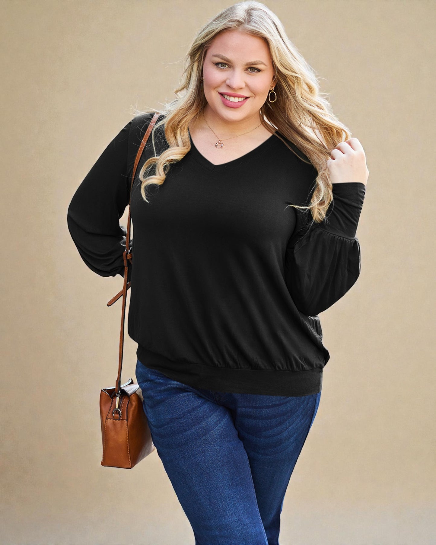 Woman wearing a black sweater and blue jeans with a brown handbag on a beige background