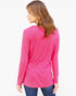 A woman with long light brown hair is shown from the back wearing a bright pink long-sleeve top and blue jeans against a plain white background.