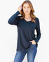 A woman modeling a dark navy blue long-sleeve V-neck top with a chest pocket, paired with blue jeans, against a plain white background.