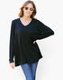 A woman modeling a black long-sleeve V-neck tunic top with blue jeans against a plain white background.