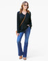 A woman modeling a black long-sleeve V-neck top with blue jeans, sunglasses, and a brown crossbody bag against a plain white background.