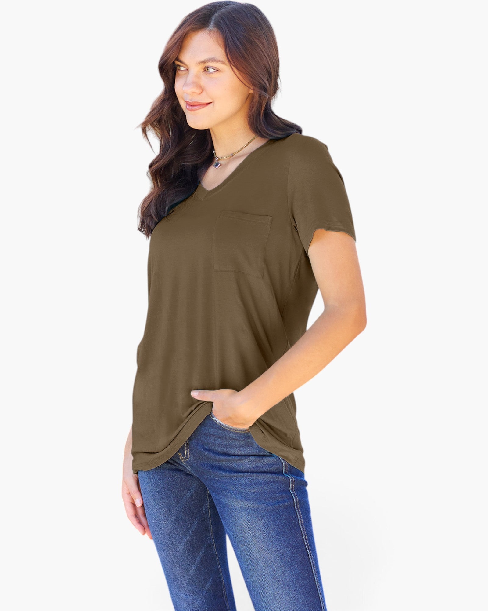 A woman wearing a short-sleeve V-neck top in olive green with a chest pocket, paired with blue jeans, photographed against a plain light background.