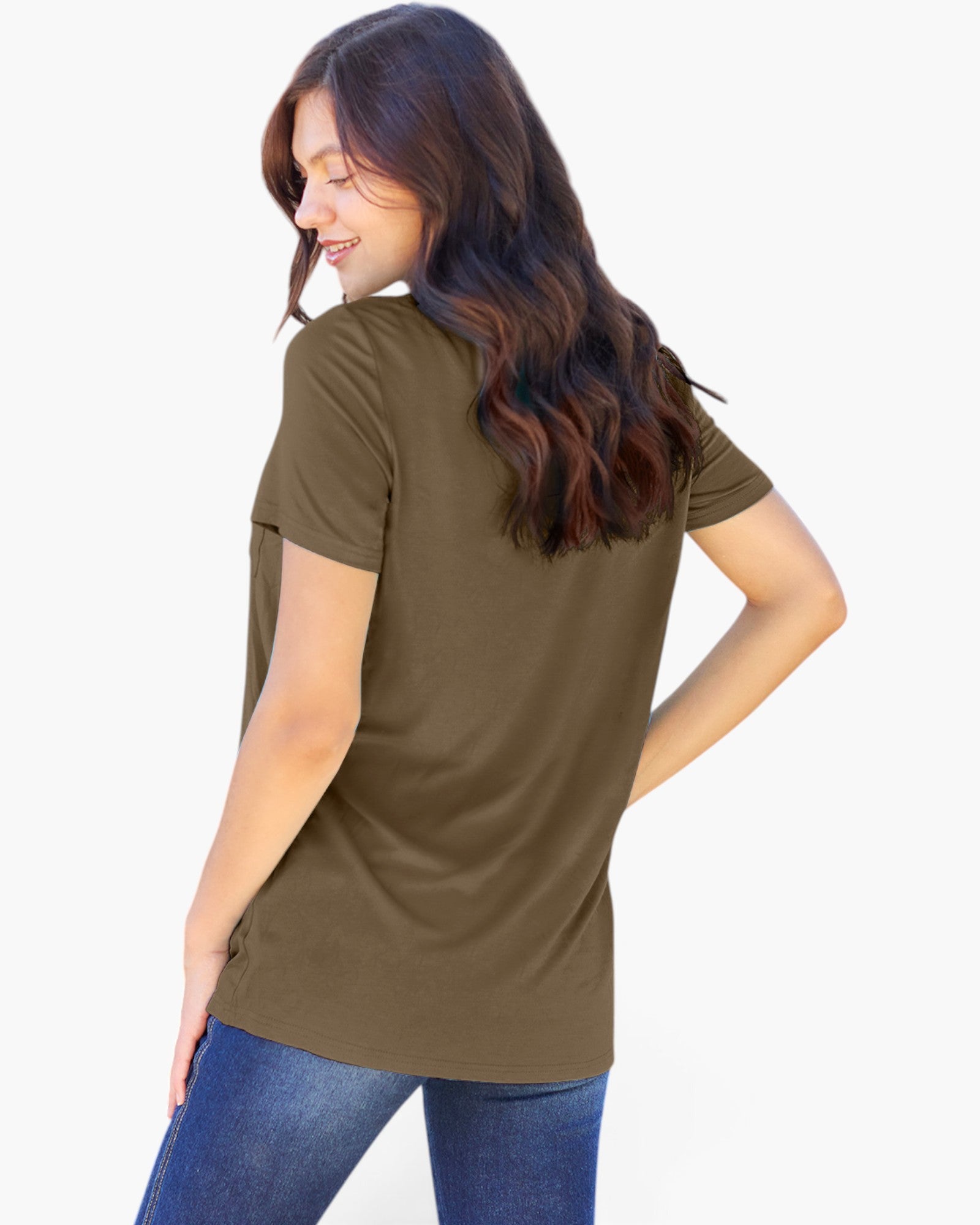 A woman with long wavy brown hair is shown from the back wearing a short-sleeve olive green t-shirt and blue jeans against a plain white background.