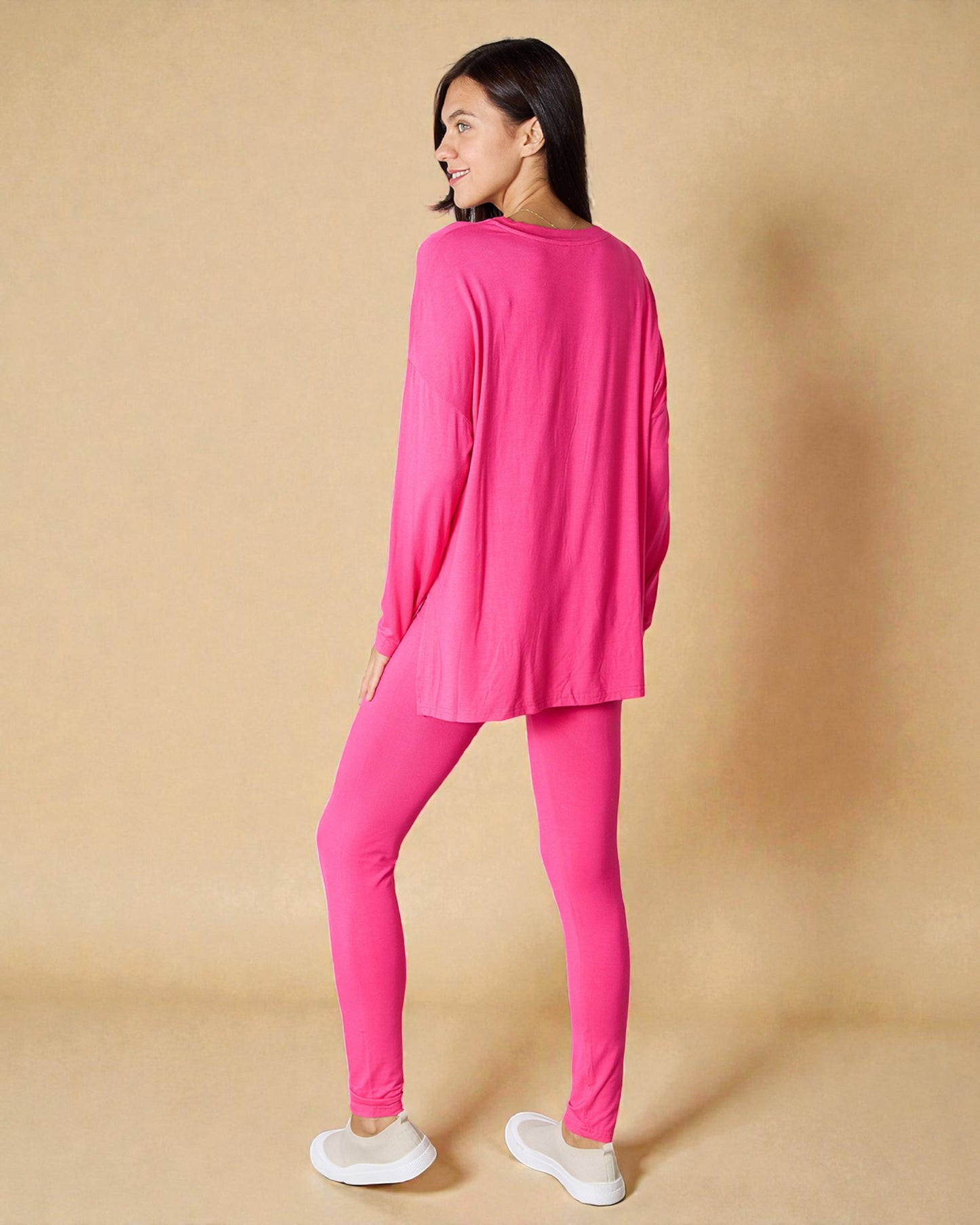 Woman wearing a bright pink outfit on a beige background