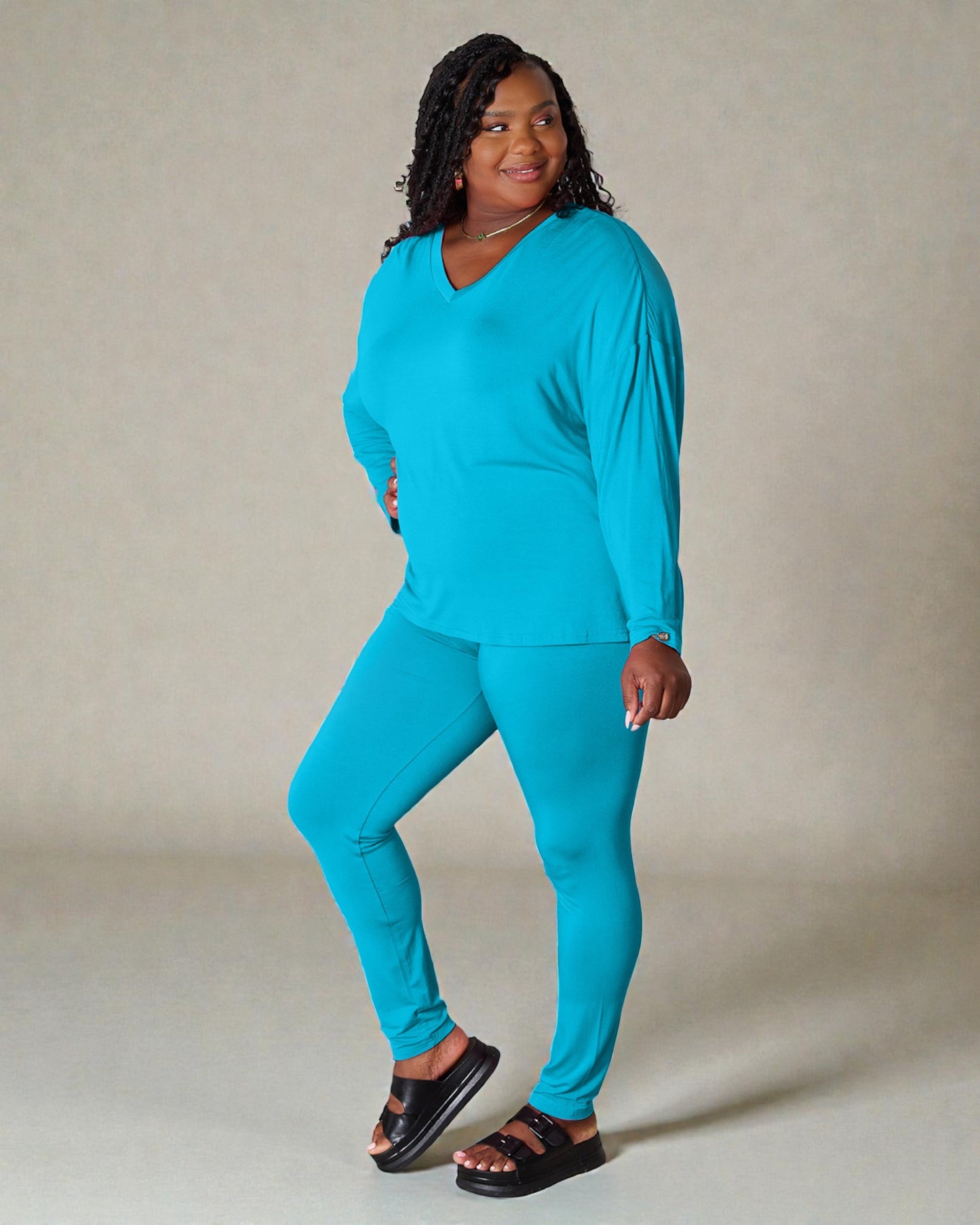 Woman wearing a turquoise outfit against a neutral background
