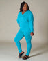 Woman wearing a turquoise outfit against a neutral background