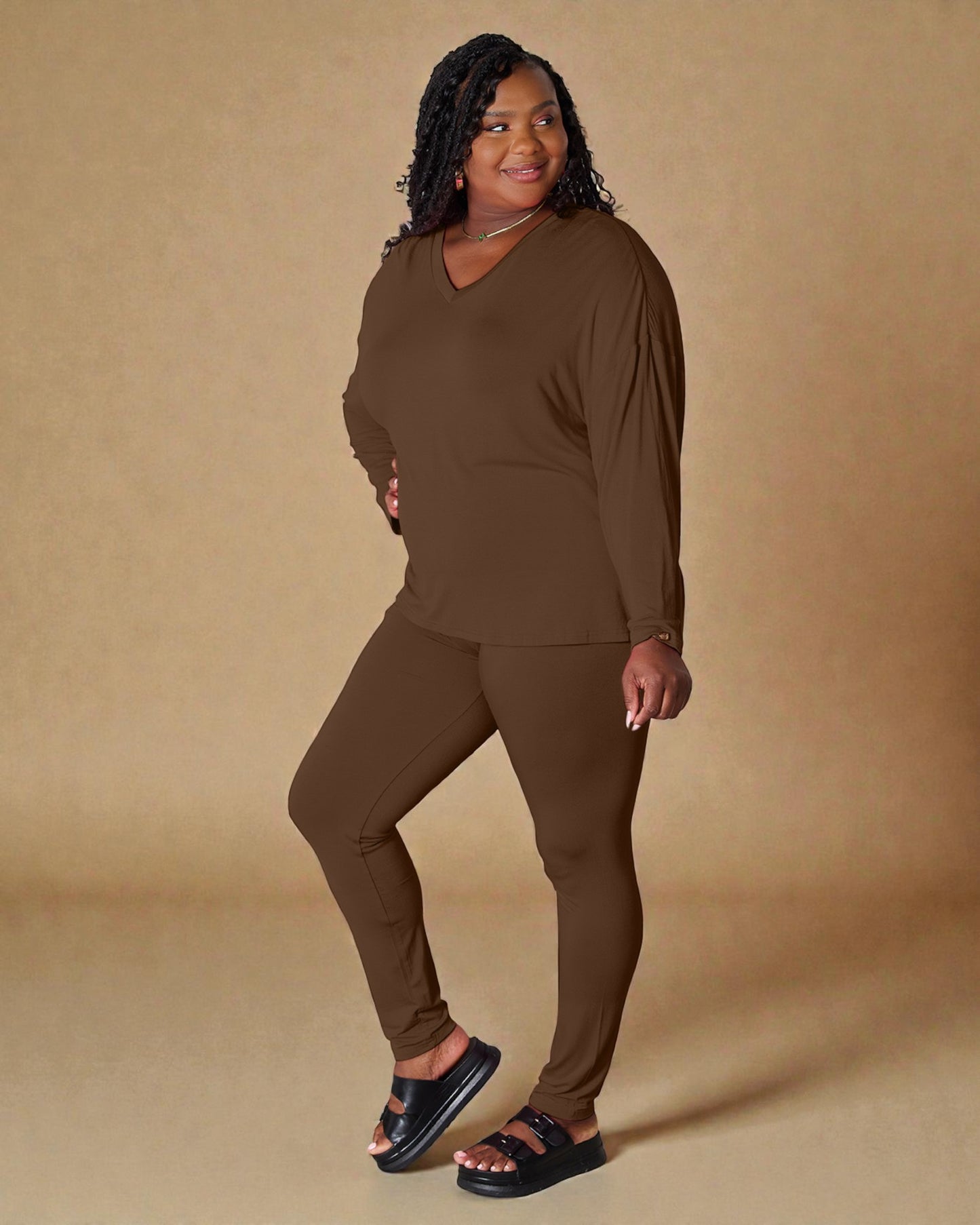 Woman wearing a brown outfit against a beige background