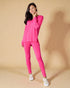 Woman wearing a bright pink outfit on a beige background