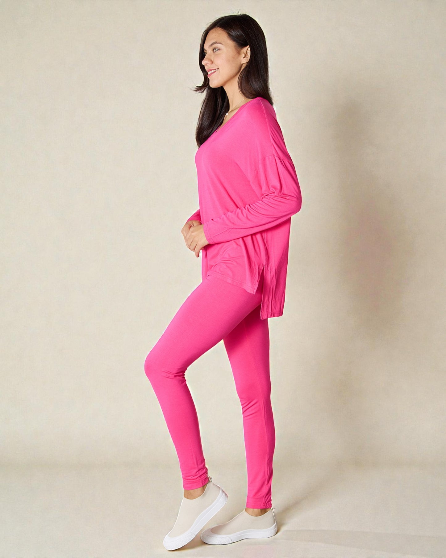 Woman wearing a bright pink outfit on a beige background