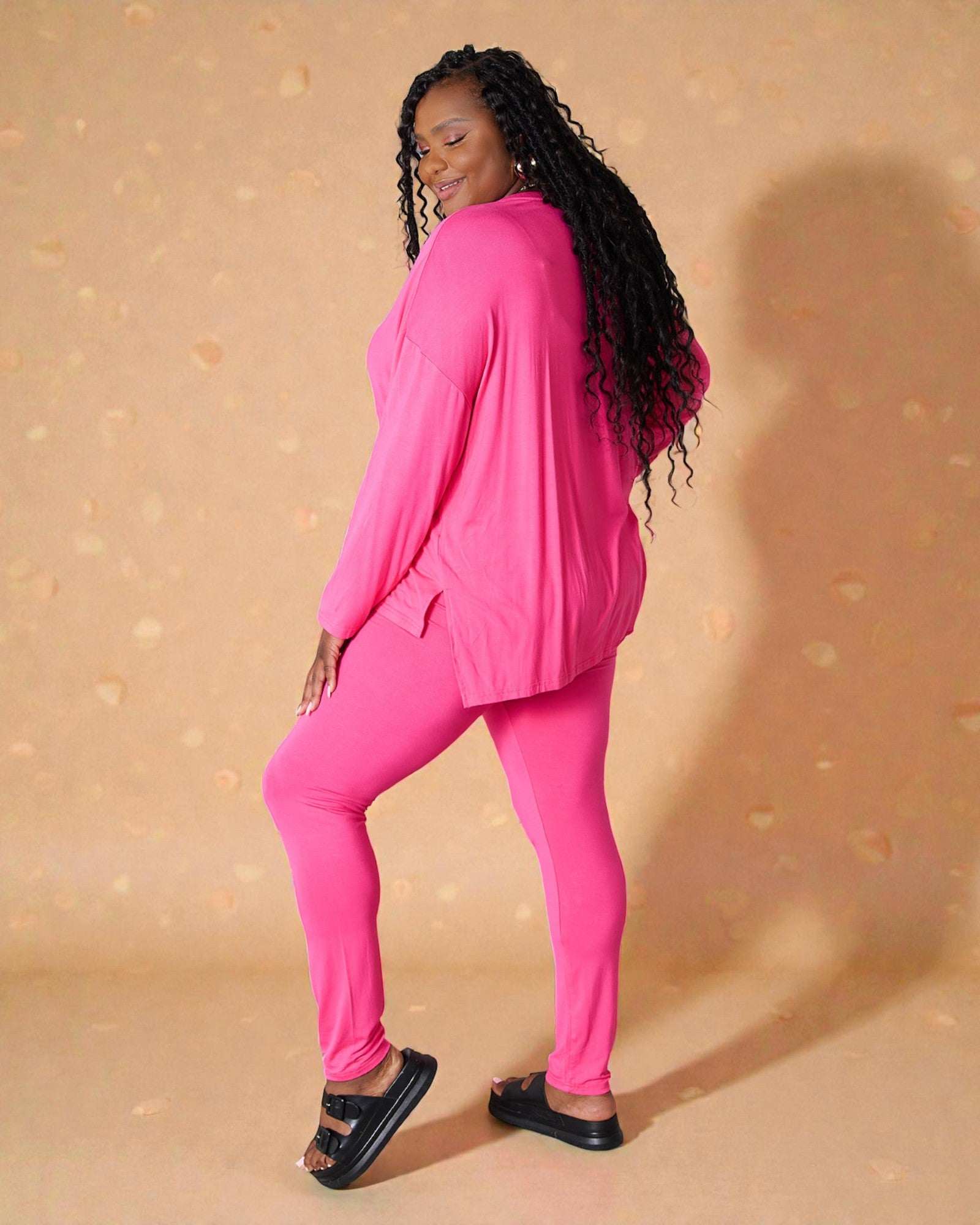 Woman wearing a bright pink outfit against a beige background