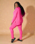 Woman wearing a bright pink outfit against a beige background