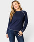 Woman wearing a navy long-sleeve top with white trim on a light gray background
