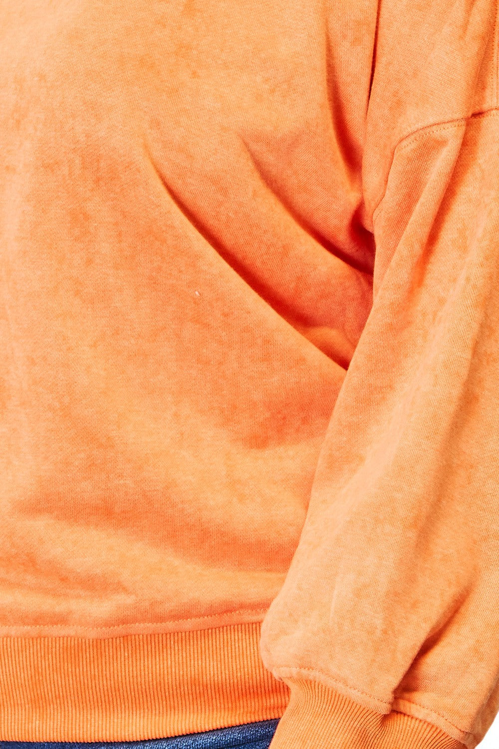 Close-up of an orange sweatshirt with a focus on texture and color.
