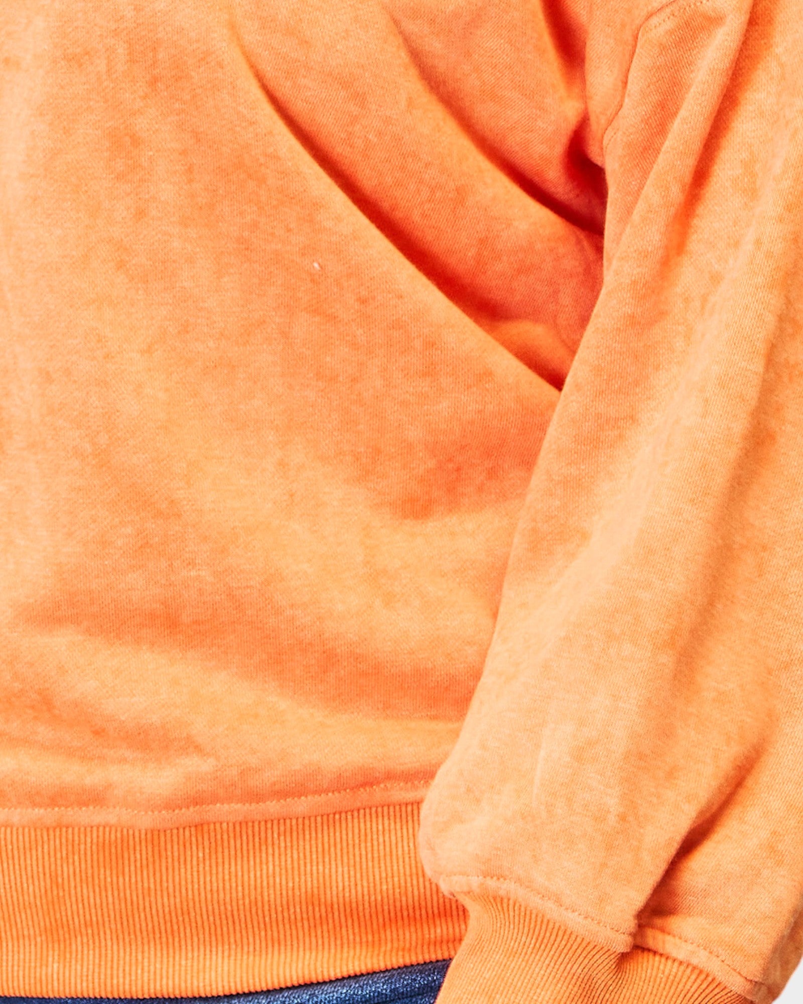 Close-up of an orange sweatshirt with a focus on texture and color.