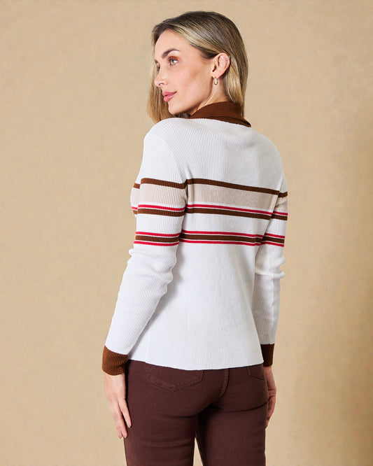 Woman wearing a white sweater with brown and red stripes on a beige background