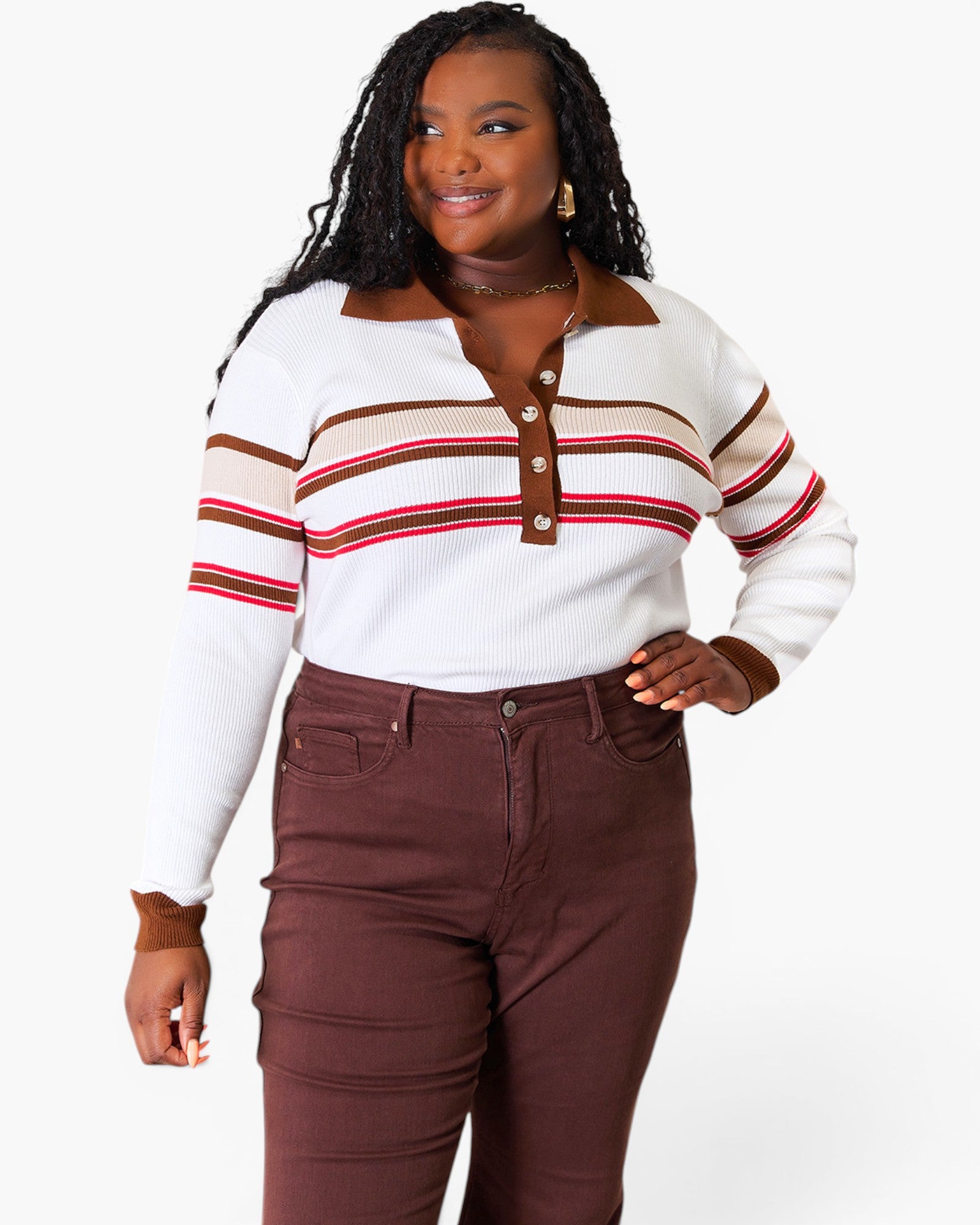 A woman modeling a white ribbed knit polo sweater with brown and red stripes, paired with brown pants, against a plain white background.