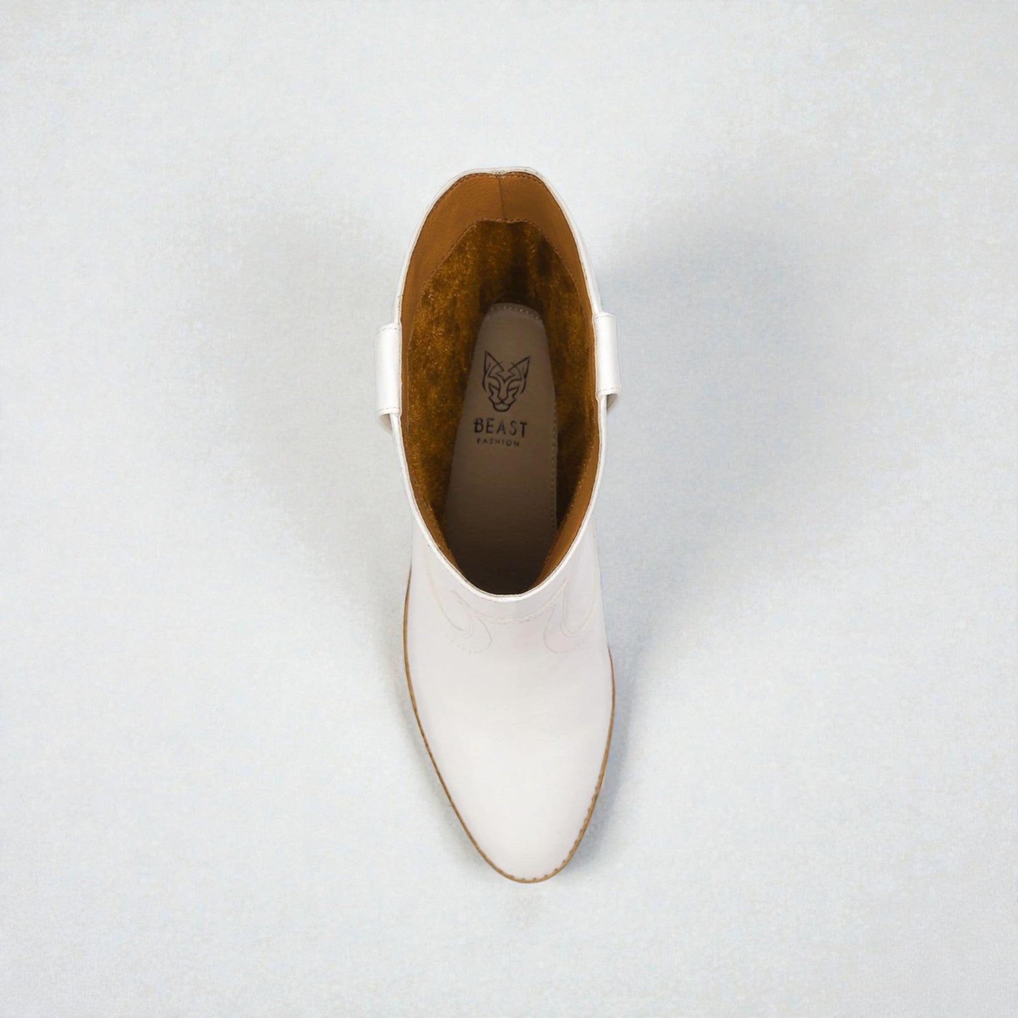 White ankle boot with brown lining on a light gray background