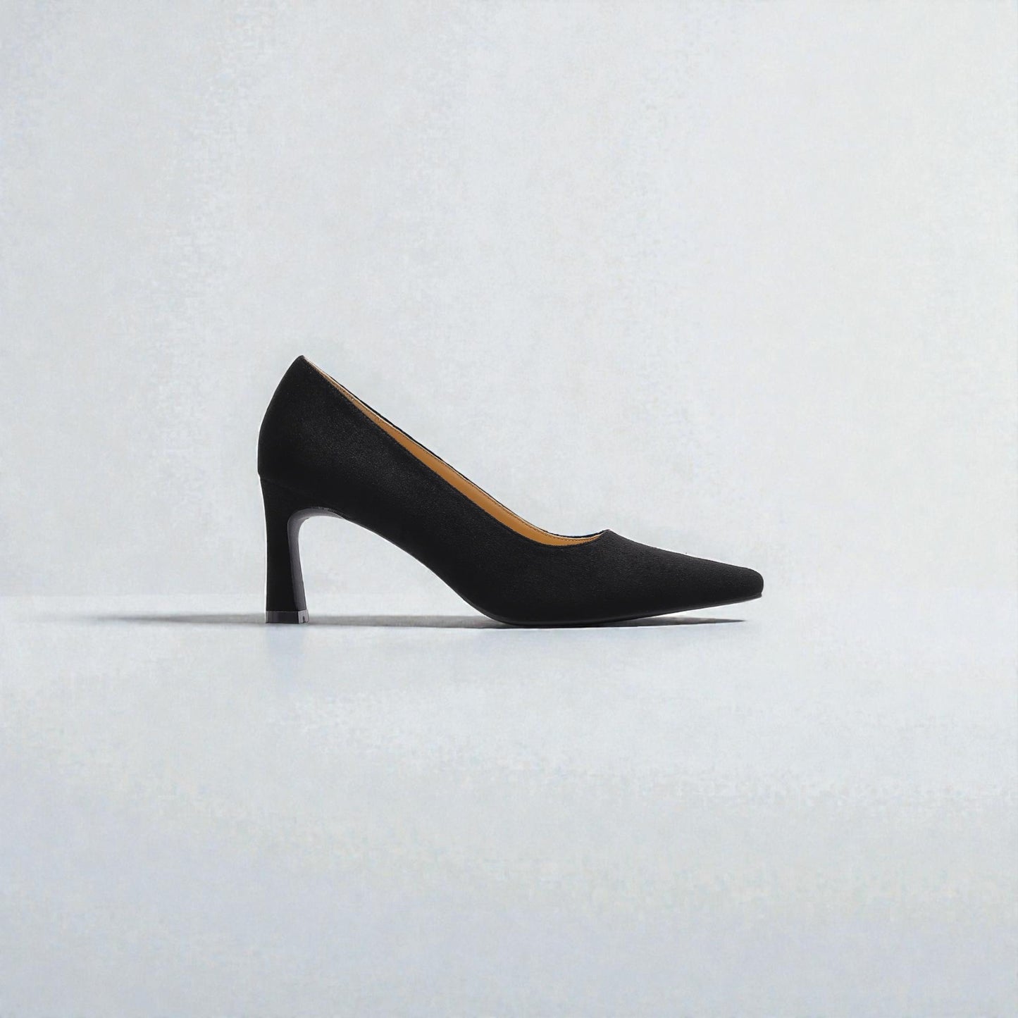 Black high-heeled shoe on a light gray background