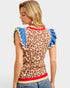 Woman wearing a leopard print top with blue ruffled sleeves on a white background