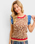 Woman wearing a leopard print sweater with blue sleeves and red trim on a white background