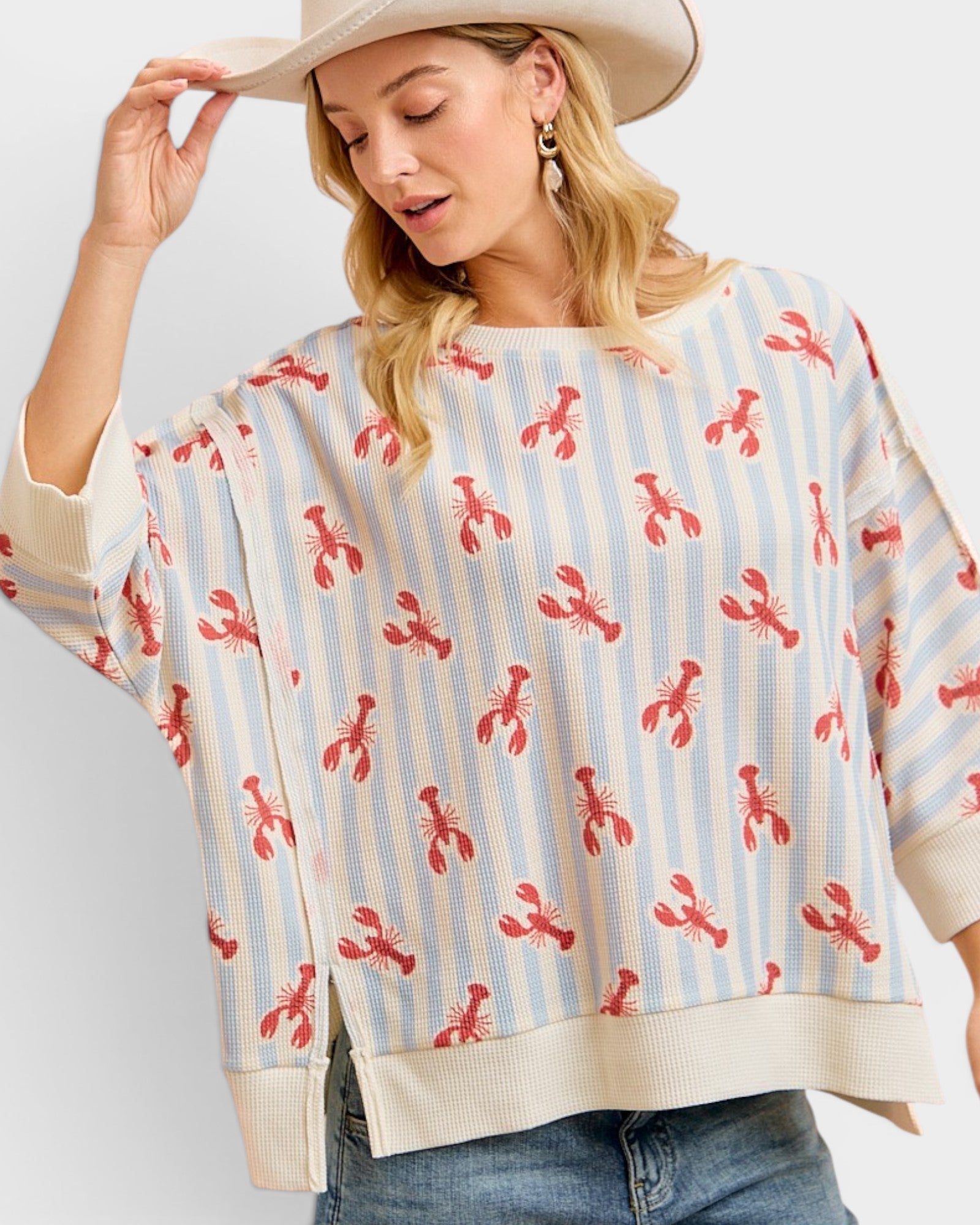 Woman wearing a striped sweater with red lobster pattern on a plain background