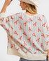 Person wearing a sweater with red lobster pattern on a white background