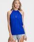 Woman wearing a blue halter top and denim shorts on a white background