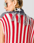 Person wearing a red, white, and blue striped sleeveless top with fringe details.