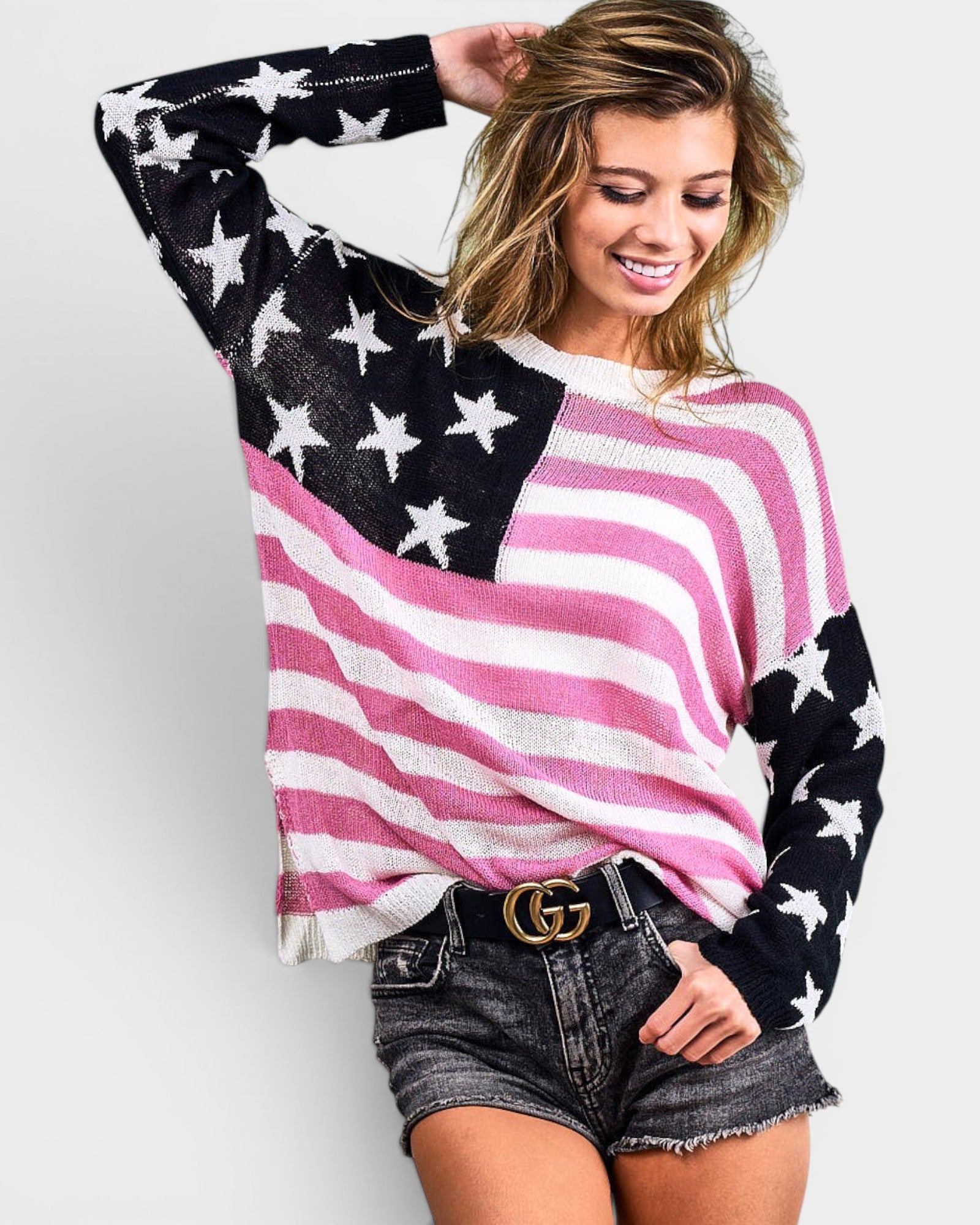 Woman wearing an American flag sweater on a plain background