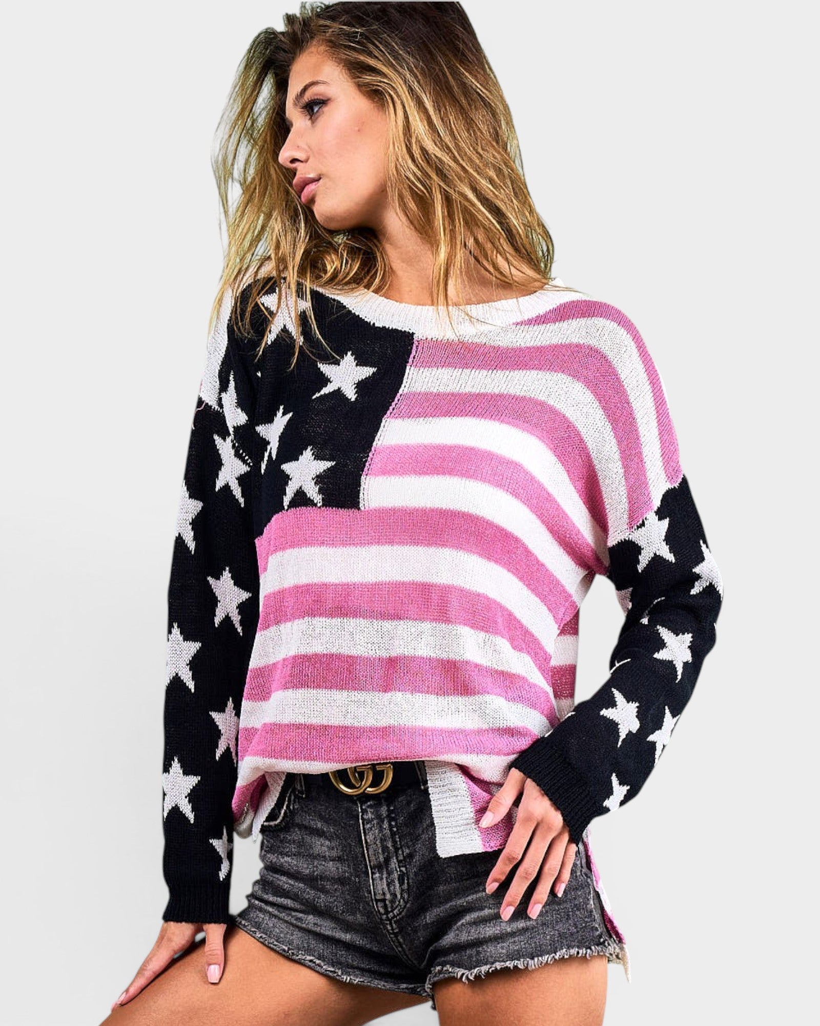 Woman wearing a colorful sweater with American flag design on a plain background