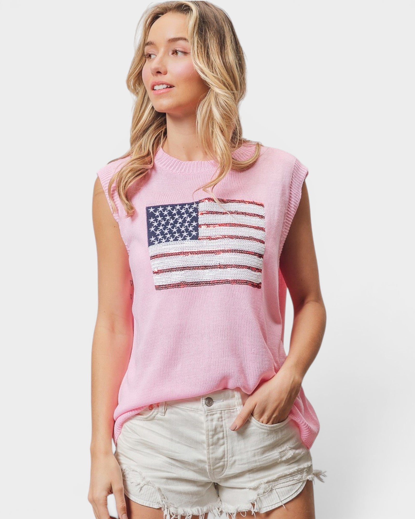 Woman wearing a pink sleeveless top with an American flag design on a white background