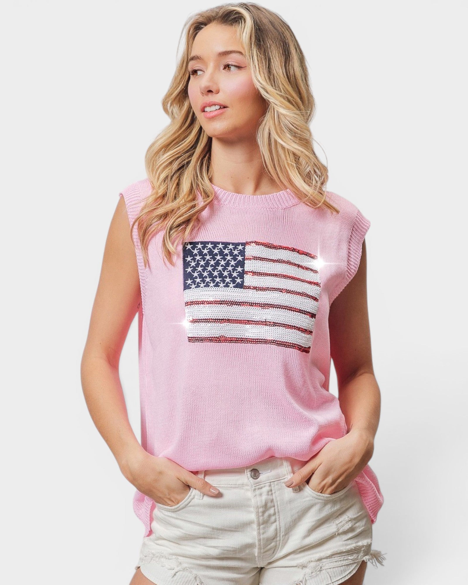 Woman wearing a pink sleeveless top with an American flag design on a white background