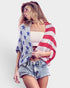 Woman wearing a colorful American flag shawl on a plain background