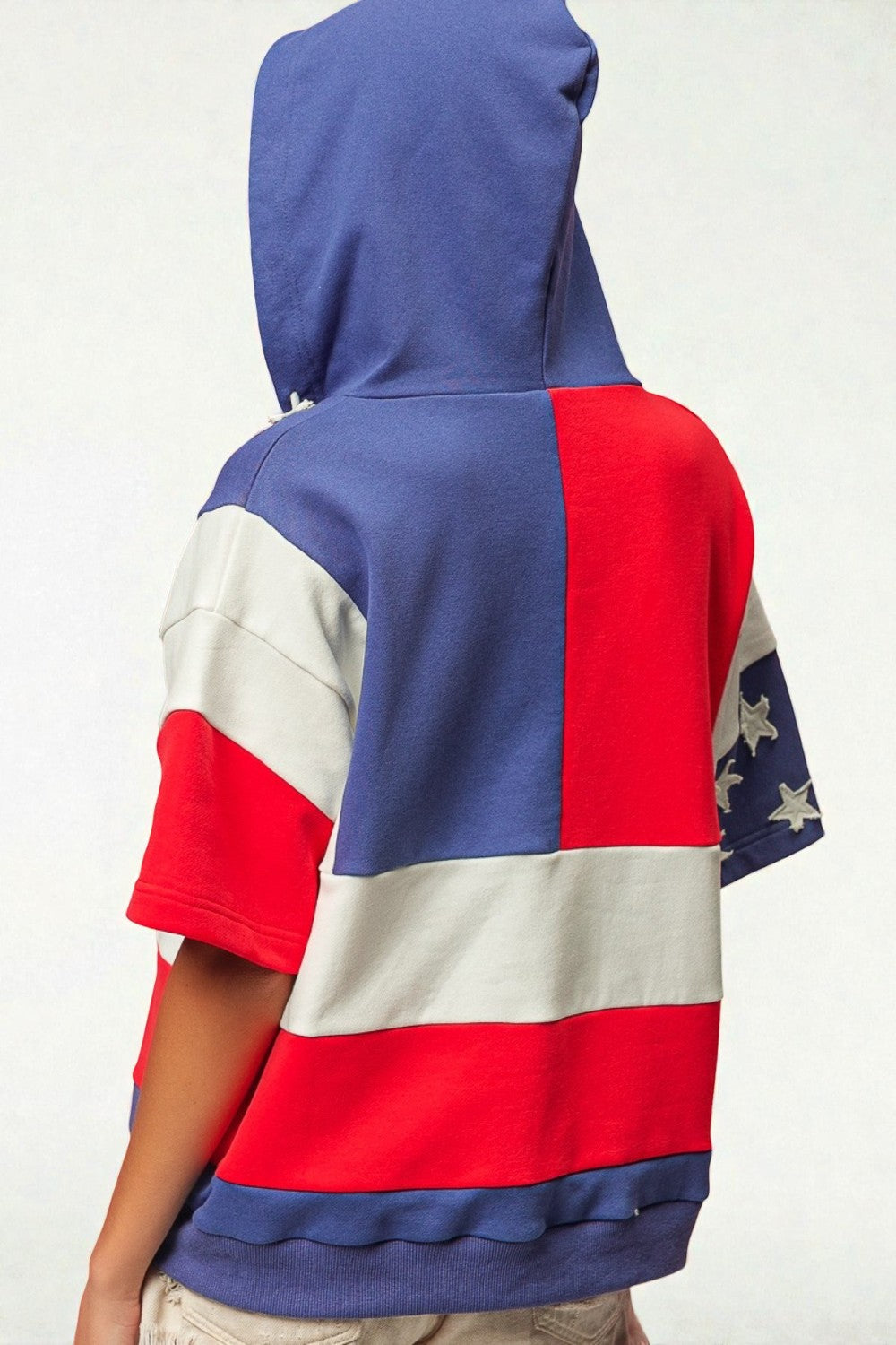 Person wearing a hoodie with a colorful pattern on a white background