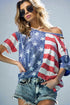 Woman wearing a colorful off-shoulder top with star pattern against a gray background