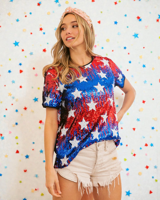 Woman wearing a colorful star-patterned shirt against a multicolored star-patterned background