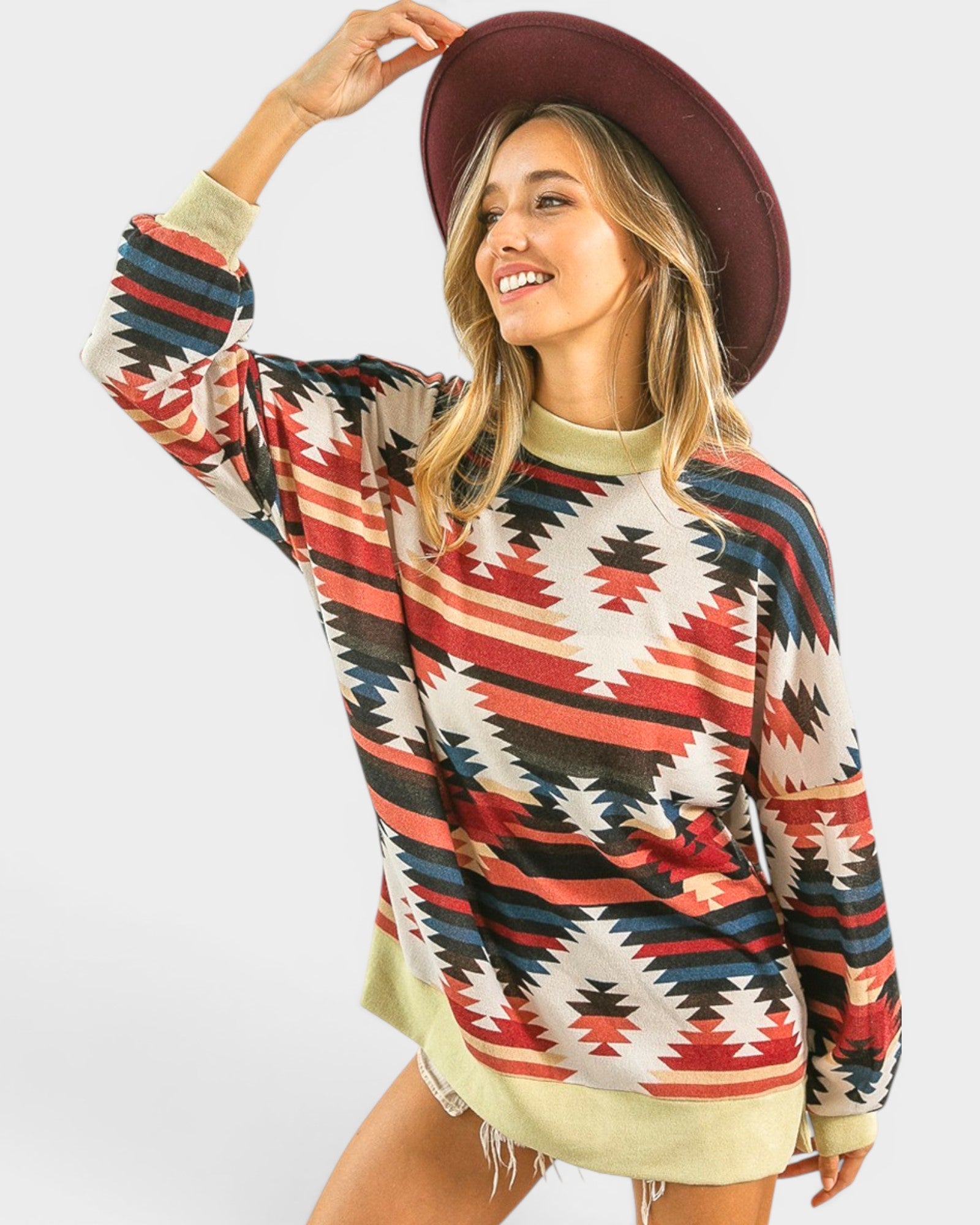 Woman wearing a colorful patterned sweater and red hat on a white background