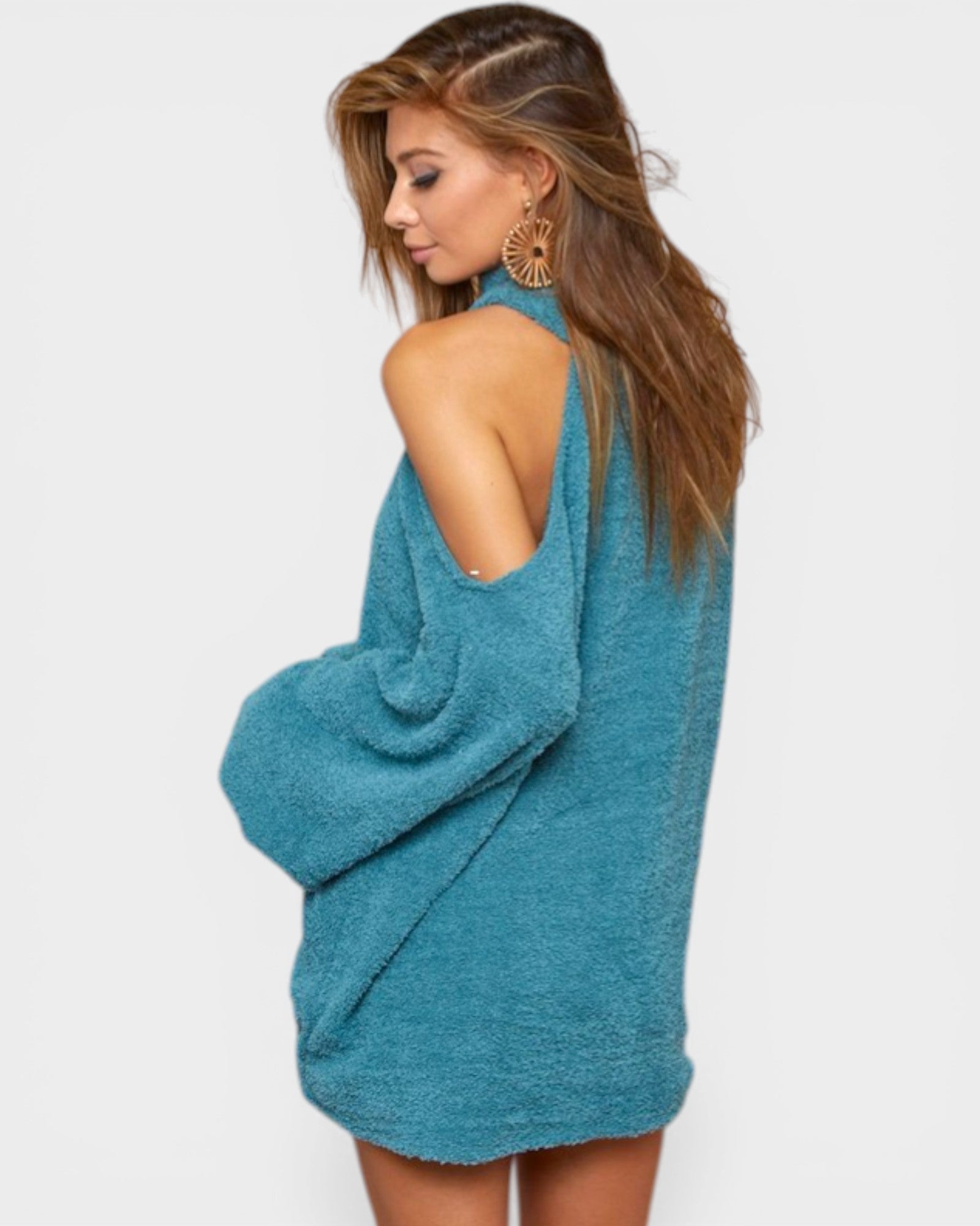 Woman wearing a teal sweater dress on a white background