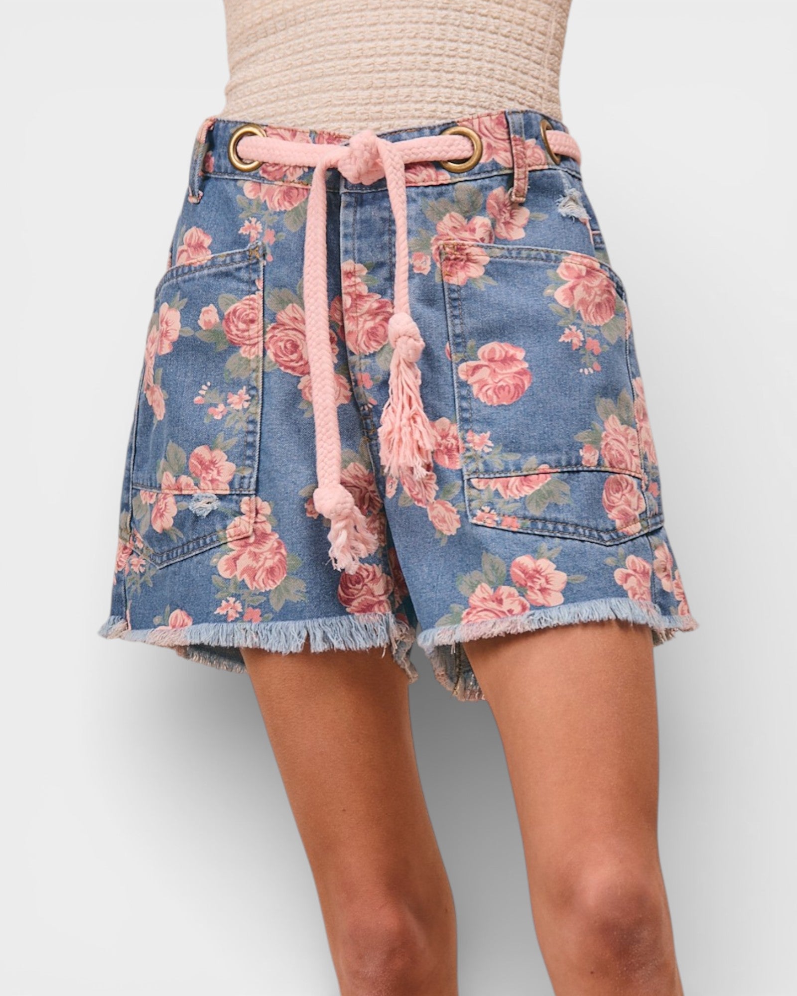 Denim skirt with floral pattern and pink drawstring on a plain background