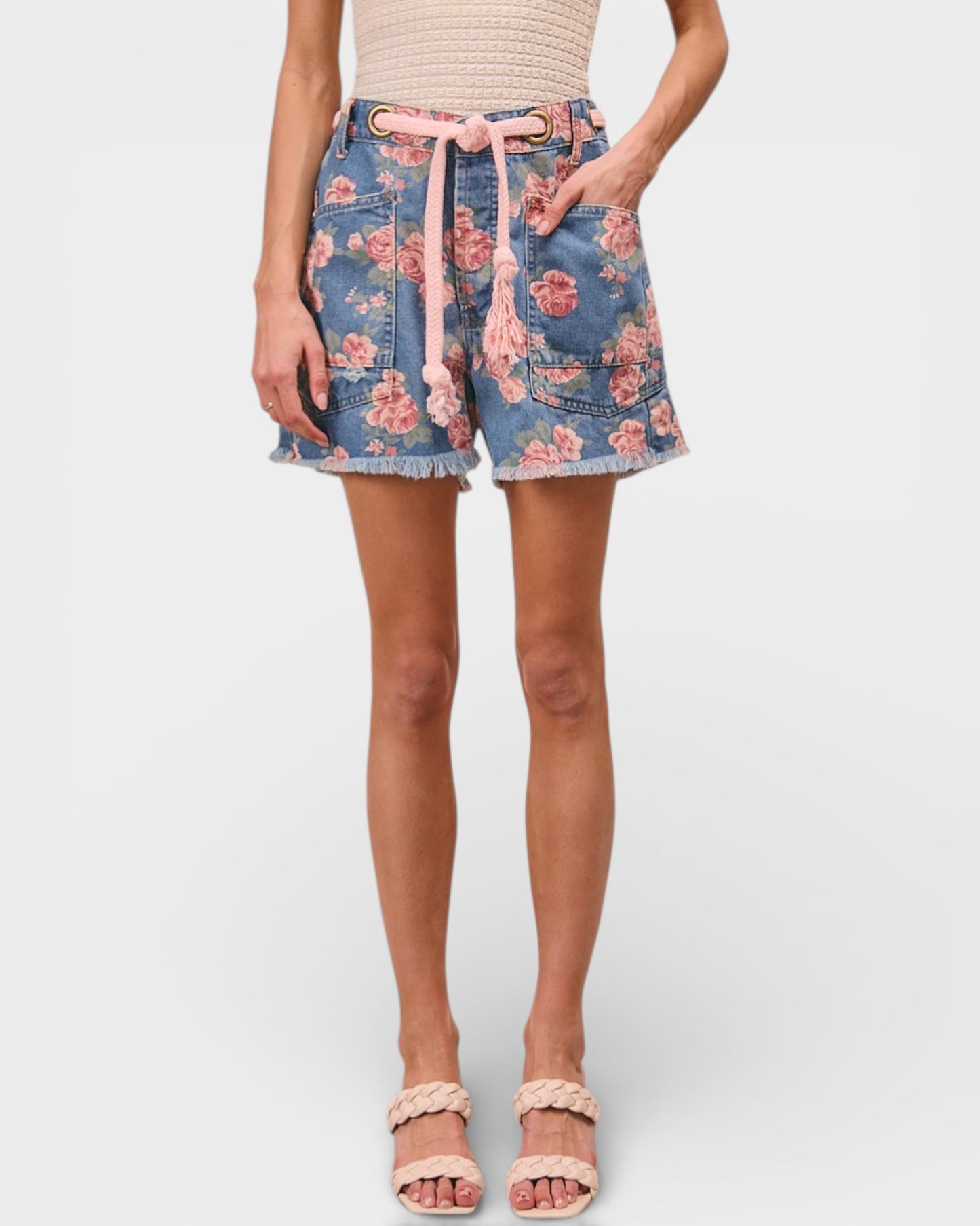 Denim shorts with floral pattern worn by a person on a white background