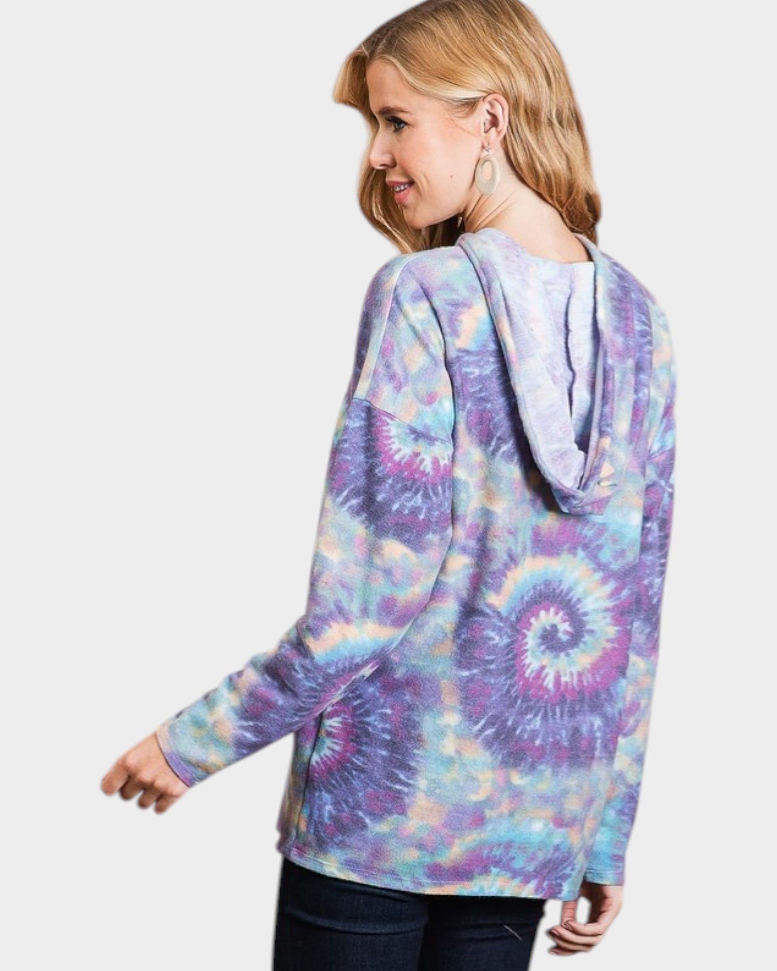 Woman wearing a tie-dye hoodie on a plain background
