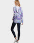 Person wearing a tie-dye hoodie and dark jeans on a white background