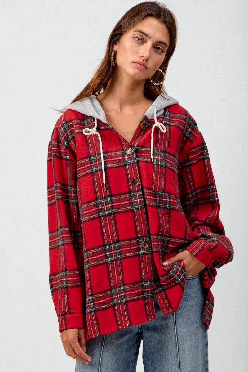 Woman wearing a red plaid shirt with a gray hood against a white background