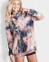 Person wearing a tie-dye hoodie with a plain background