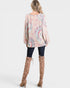 Woman wearing a floral top and brown knee-high boots on a white background