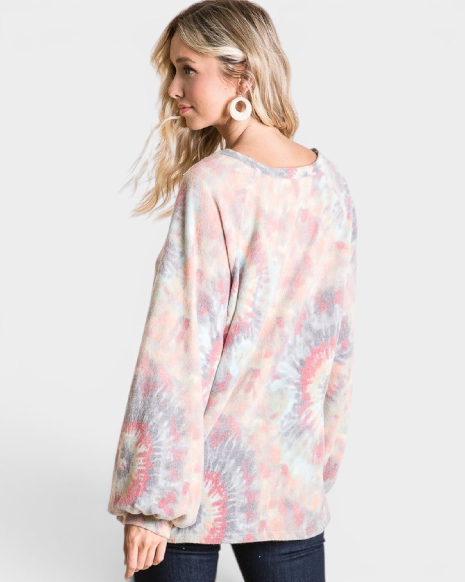 Woman wearing a tie-dye long-sleeve top on a white background