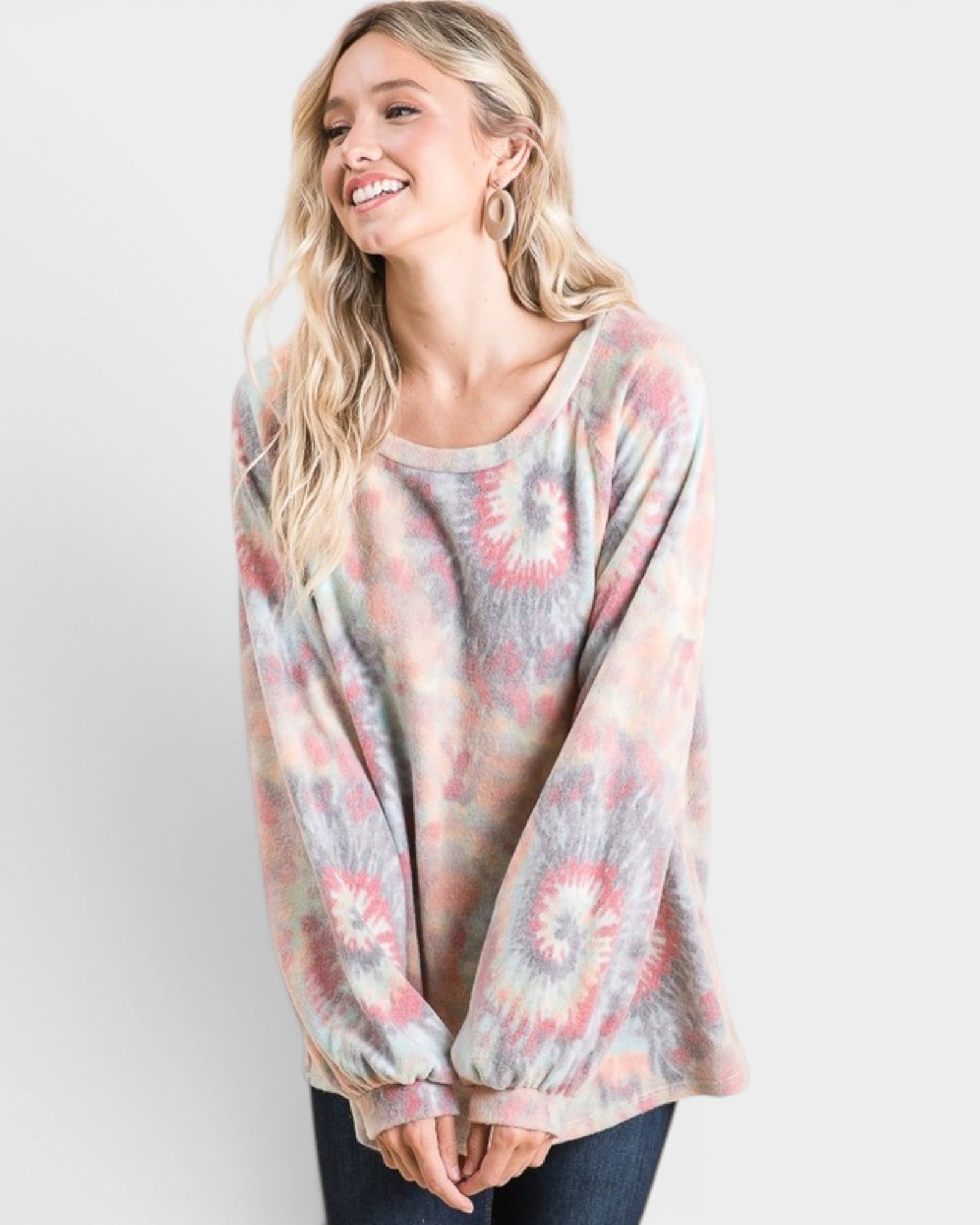 Woman wearing a tie-dye shirt against a white background