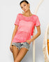 Woman wearing a pink t-shirt and denim shorts on a plain background