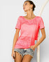 Woman wearing a pink ombre t-shirt and denim shorts on a white background